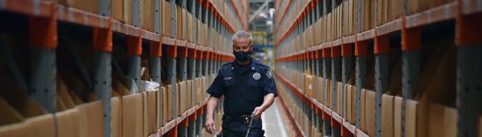 A man walks between storage bins in a warehouse